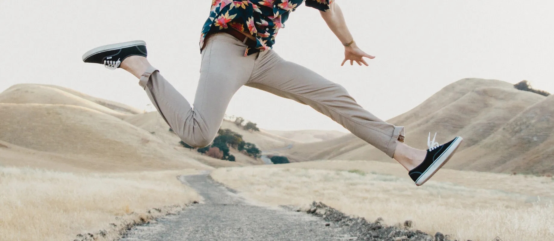 photo showing the lower body of a man jumping with his legs spit apart